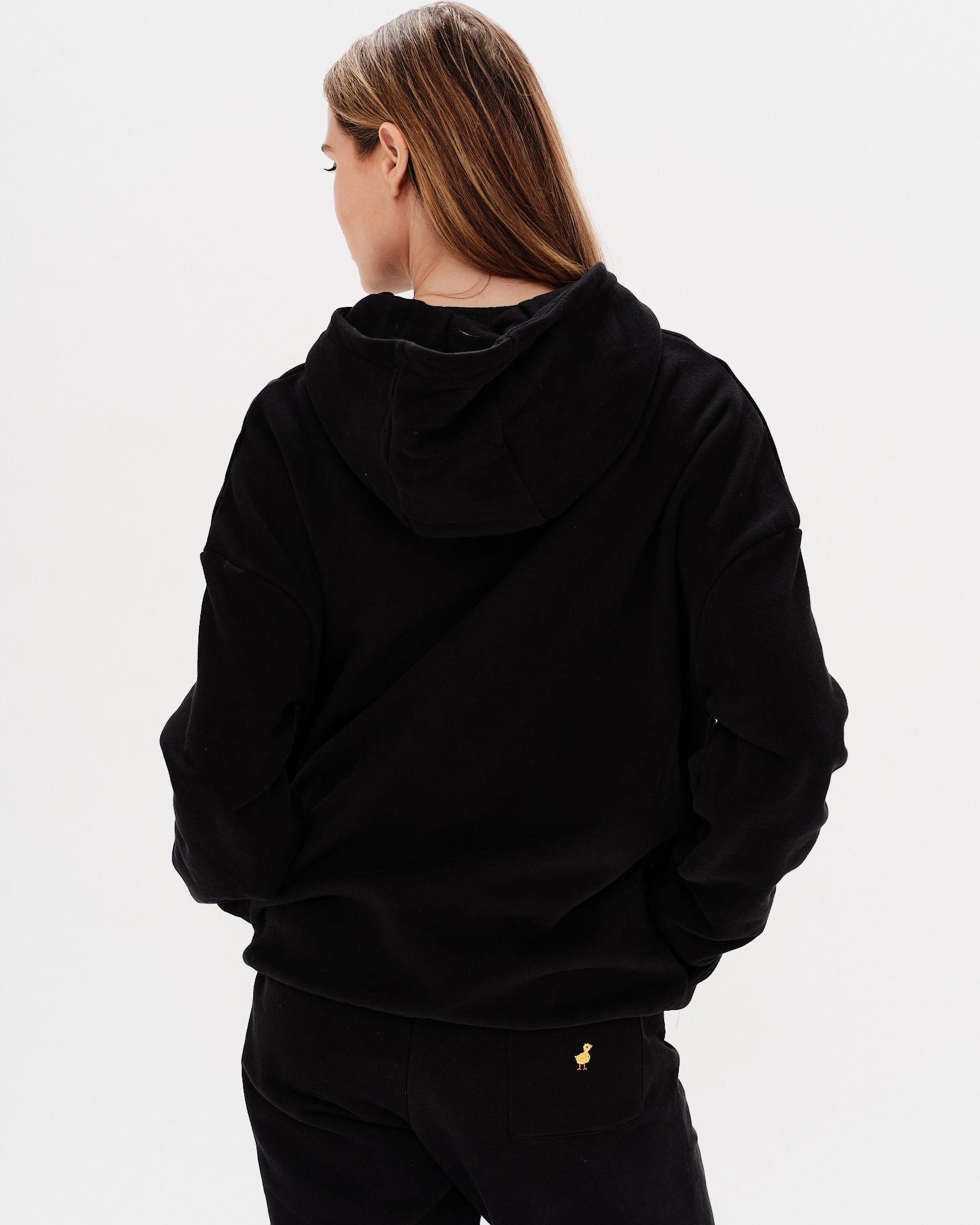 Woman wearing a premium black hoodie with a planet embroidery