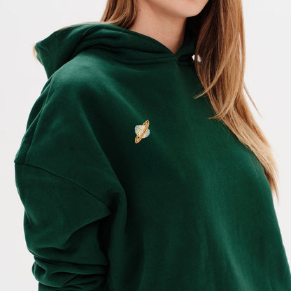 Woman wearing a premium black hoodie with a planet embroidery