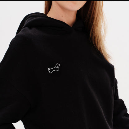 Woman wearing a red hoodie with a wiener dog embroidery