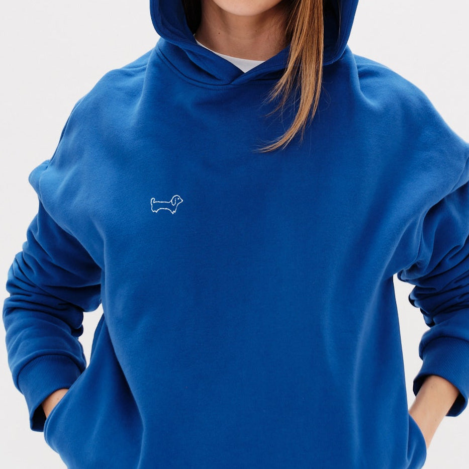 Woman wearing an blue hoodie with a wiener dog embroidery