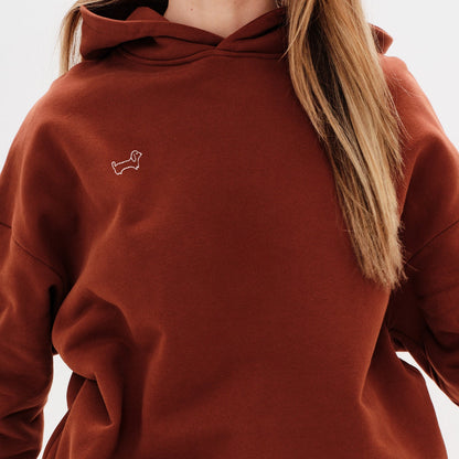 Woman wearing a red hoodie with a wiener dog embroidery