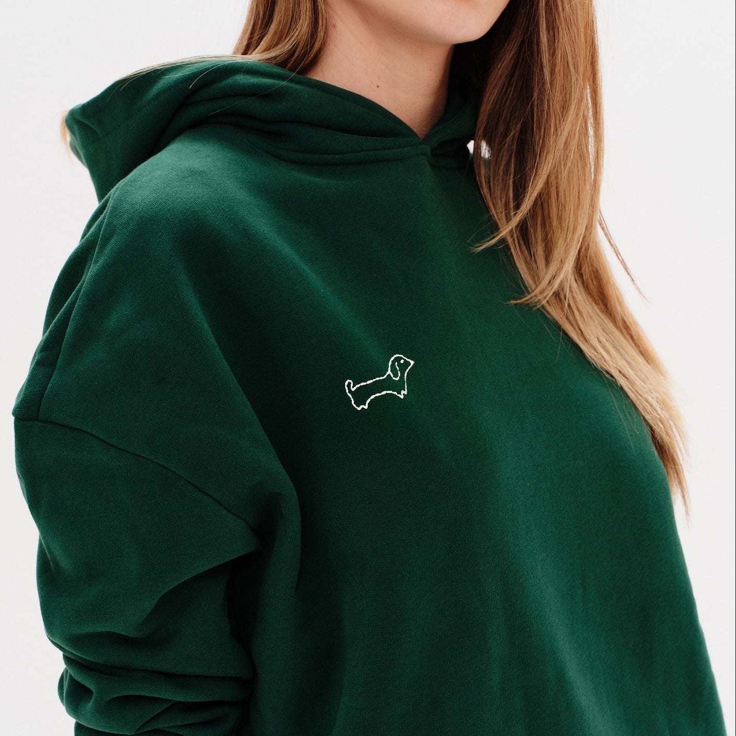 Woman wearing a red hoodie with a wiener dog embroidery