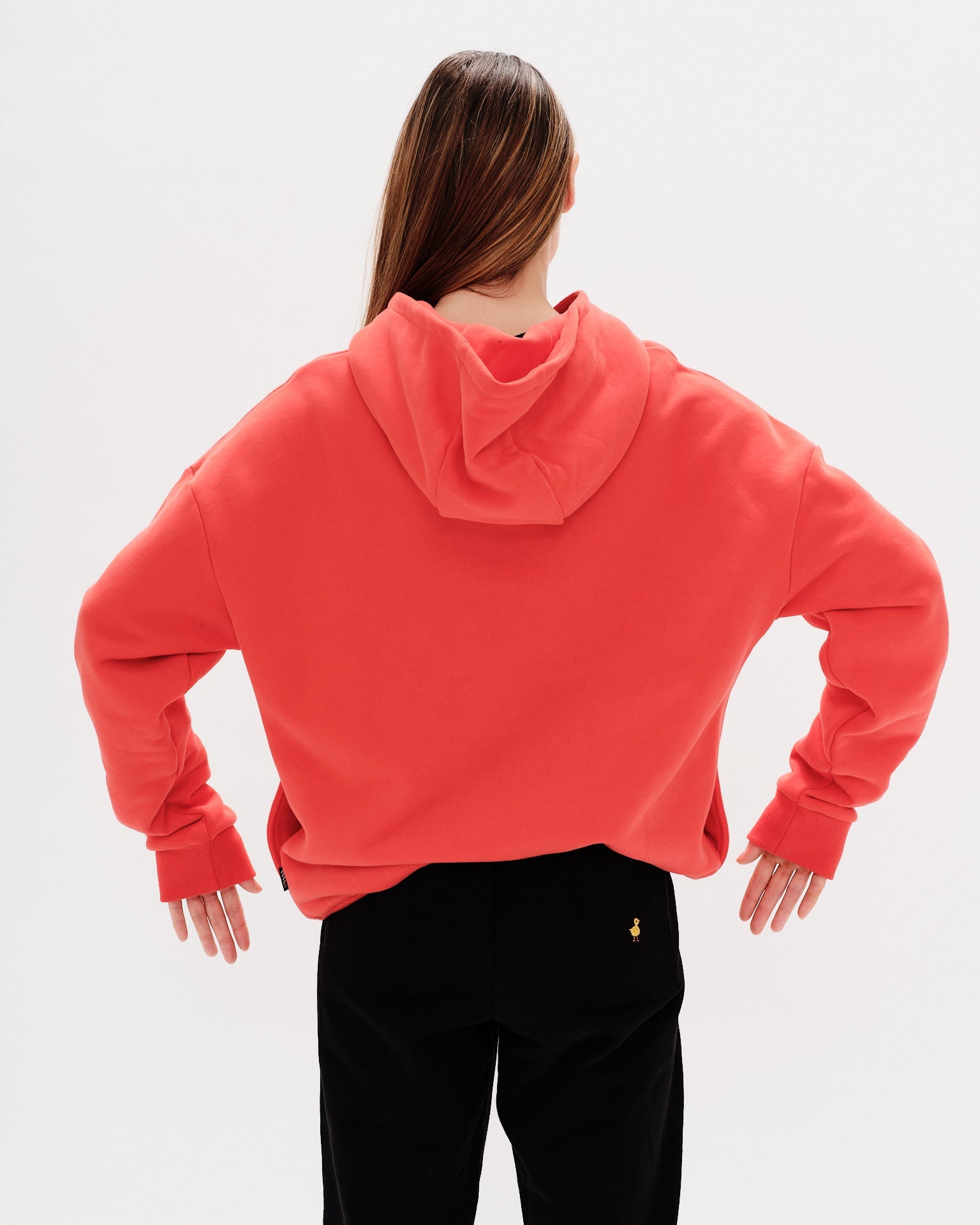 Woman wearing a red hoodie with a wiener dog embroidery