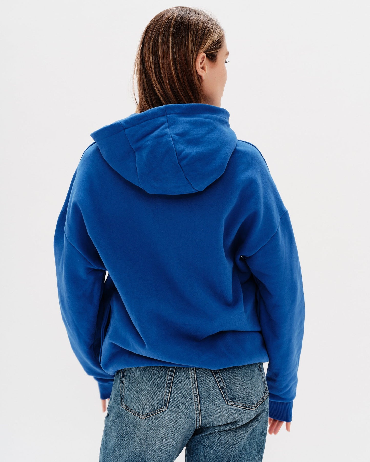 Woman wearing a blue hoodie with a 'West Village' embroidery 
