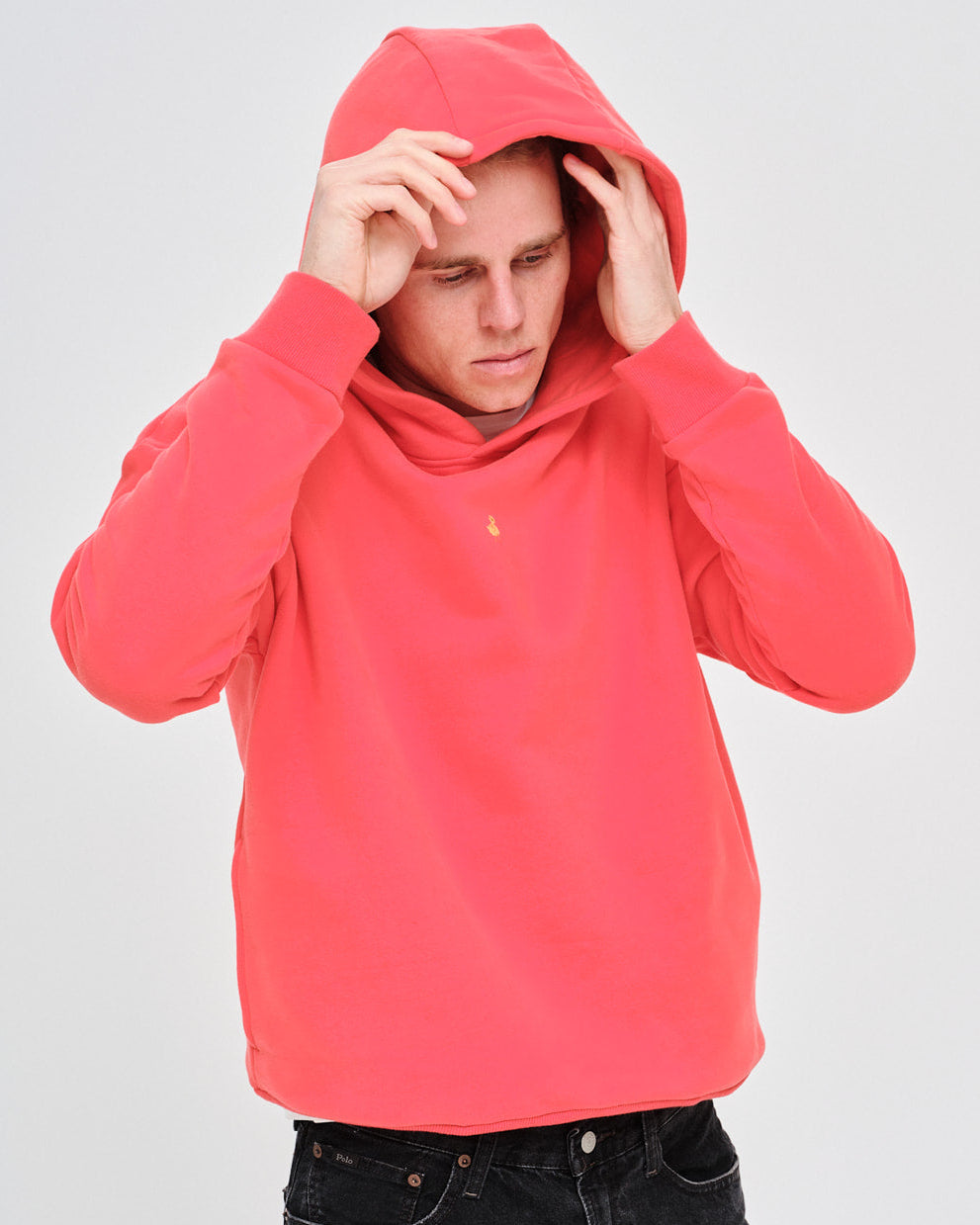 Man wearing an orange hoodie with a small duck embroidery