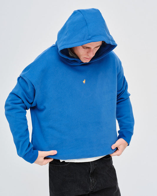 Man wearing a blue hoodie with a small duck embroidery