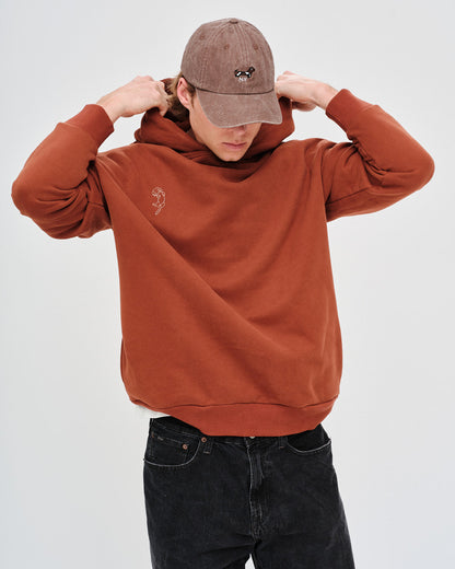 Man wearing a brown hoodie and cap