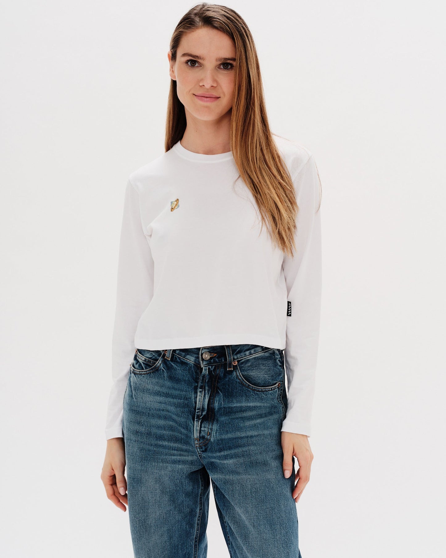 Woman wearing a white long-sleeve t-shirt with a planet design embroidery