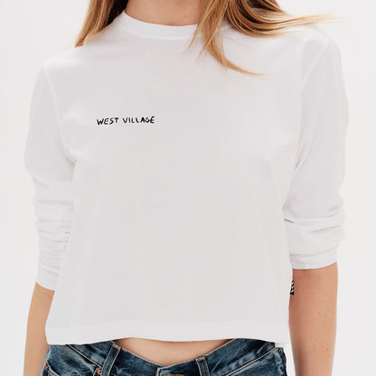 Woman wearing a white long-sleeve t-shirt with a west village embroidery