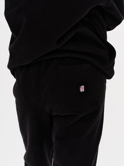 Woman wearing black pants with a Diet Coke embroidery