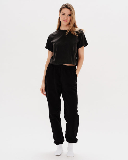 Woman wearing black pants with a Diet Coke embroidery