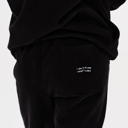 Woman wearing black pants with I dont know what i want embroidery