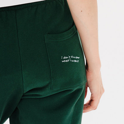 Woman wearing green pants with I dont know what i want embroidery