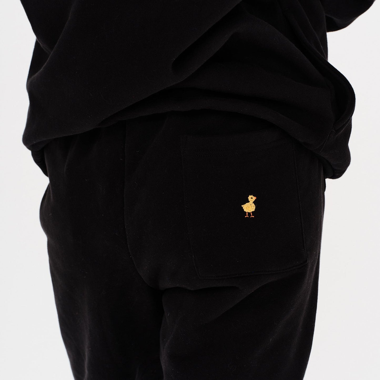 Woman wearing black pants with duck embroidery