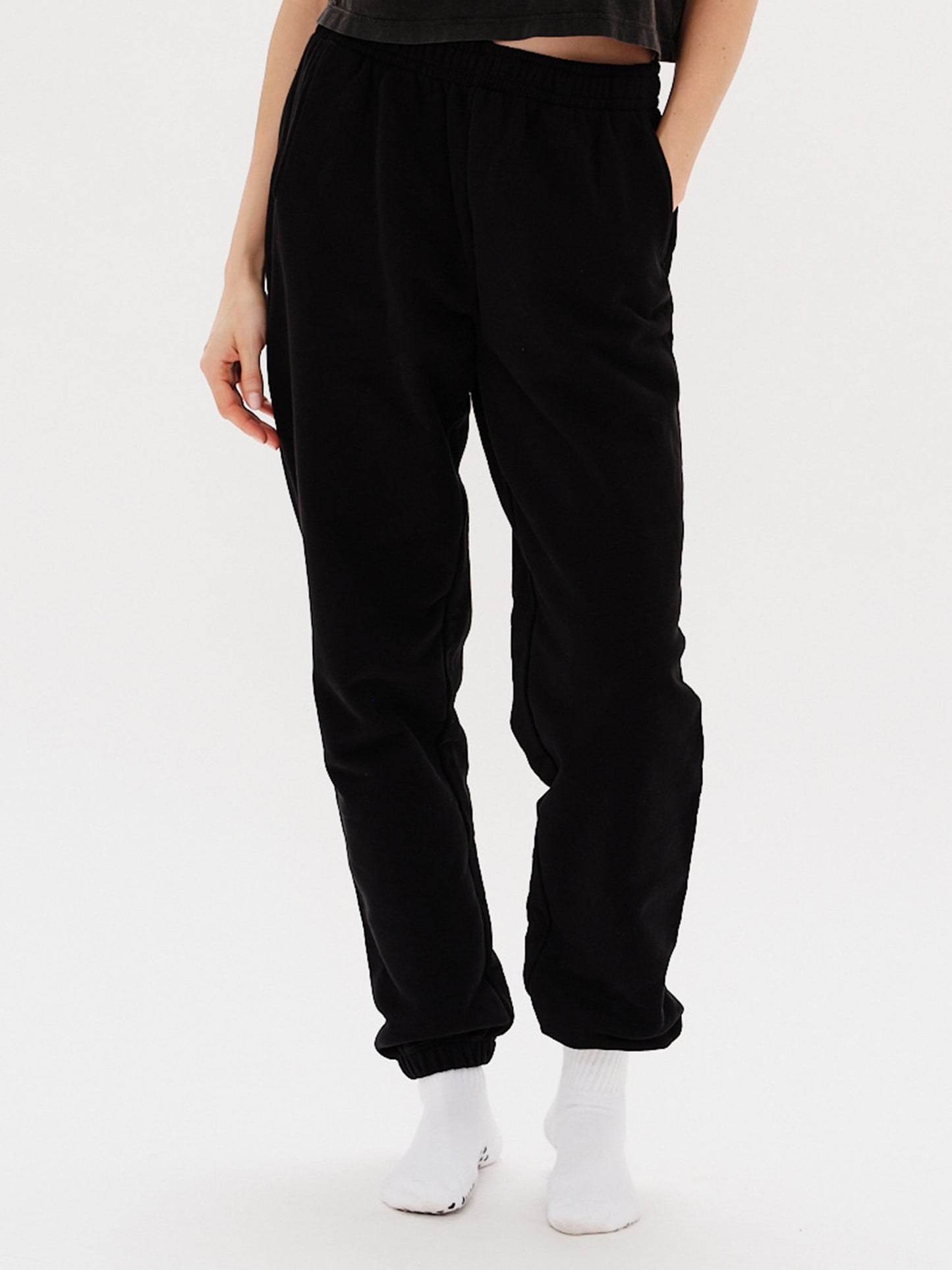 Woman wearing black pants with I'm Expensive embroidery
