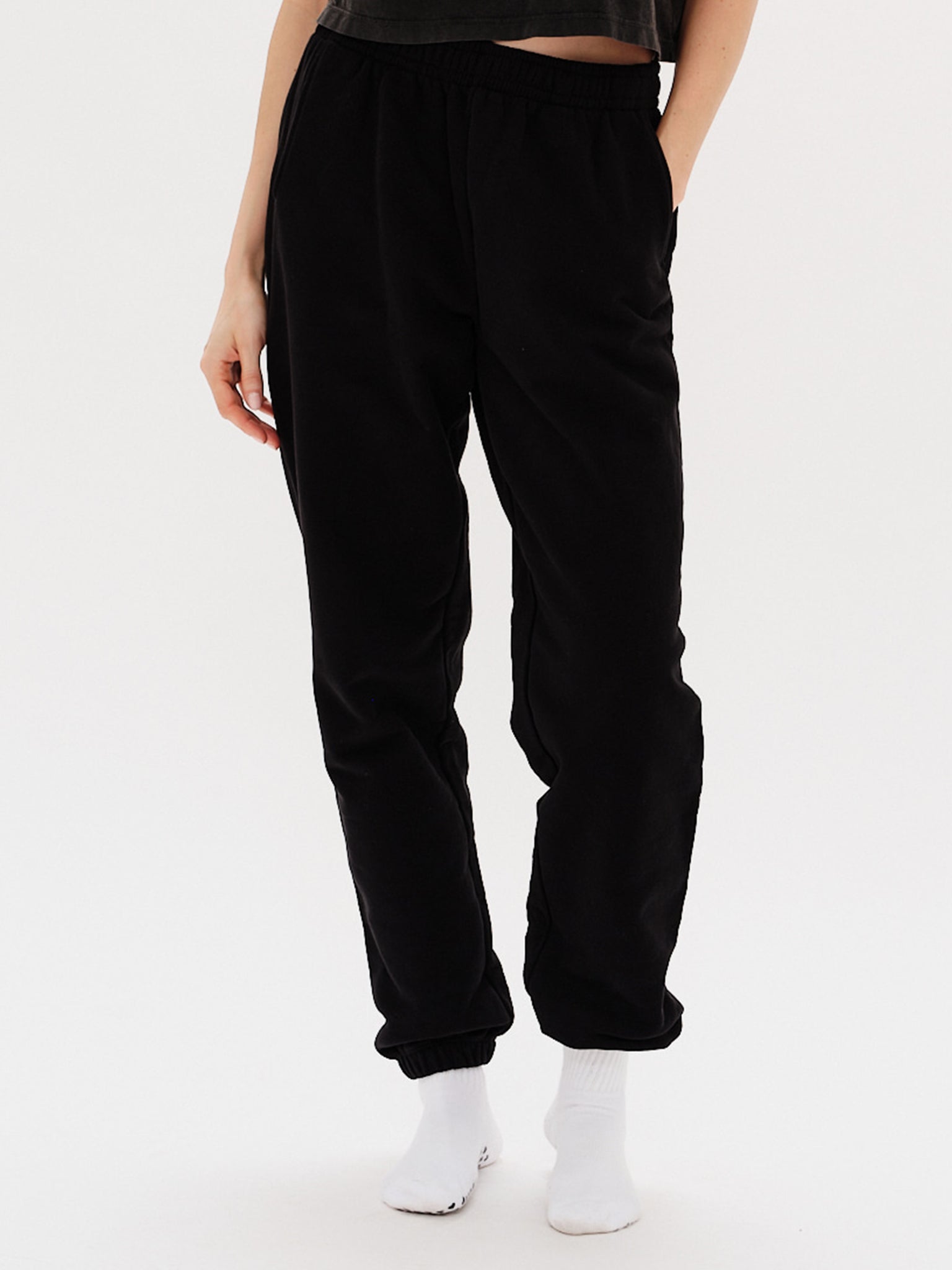 Woman wearing black pants with I'm Expensive embroidery