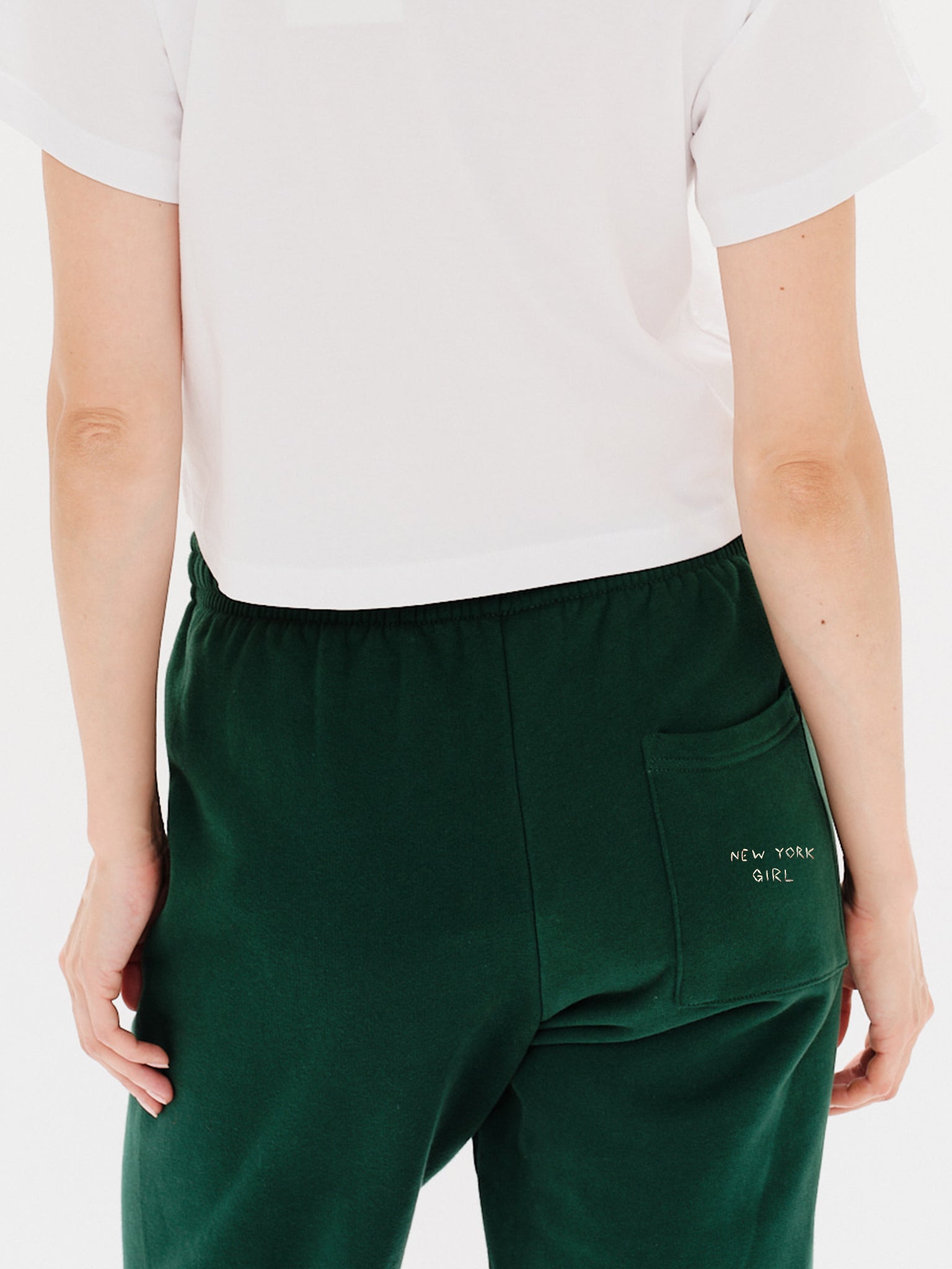 Woman wearing green pants with New York Girl embroidery