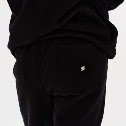 Woman wearing black pants with a planet embroidery