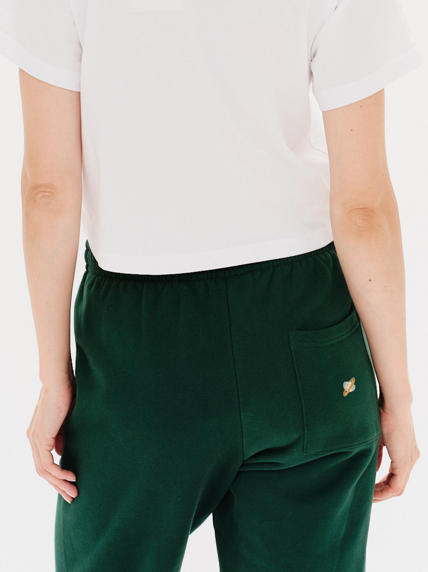Woman wearing green pants with a planet embroidery
