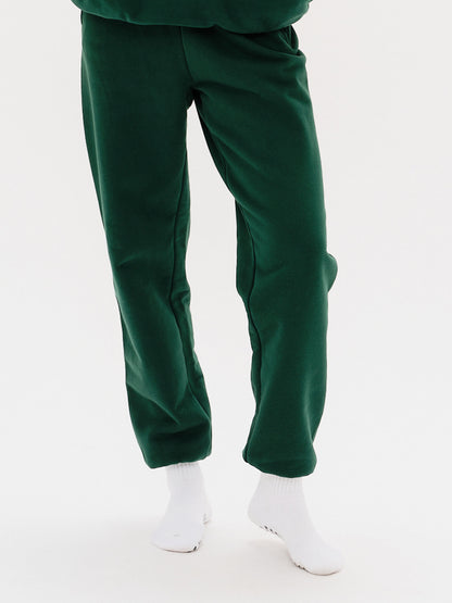 Woman wearing green pants with a Weiner Dog embroidery