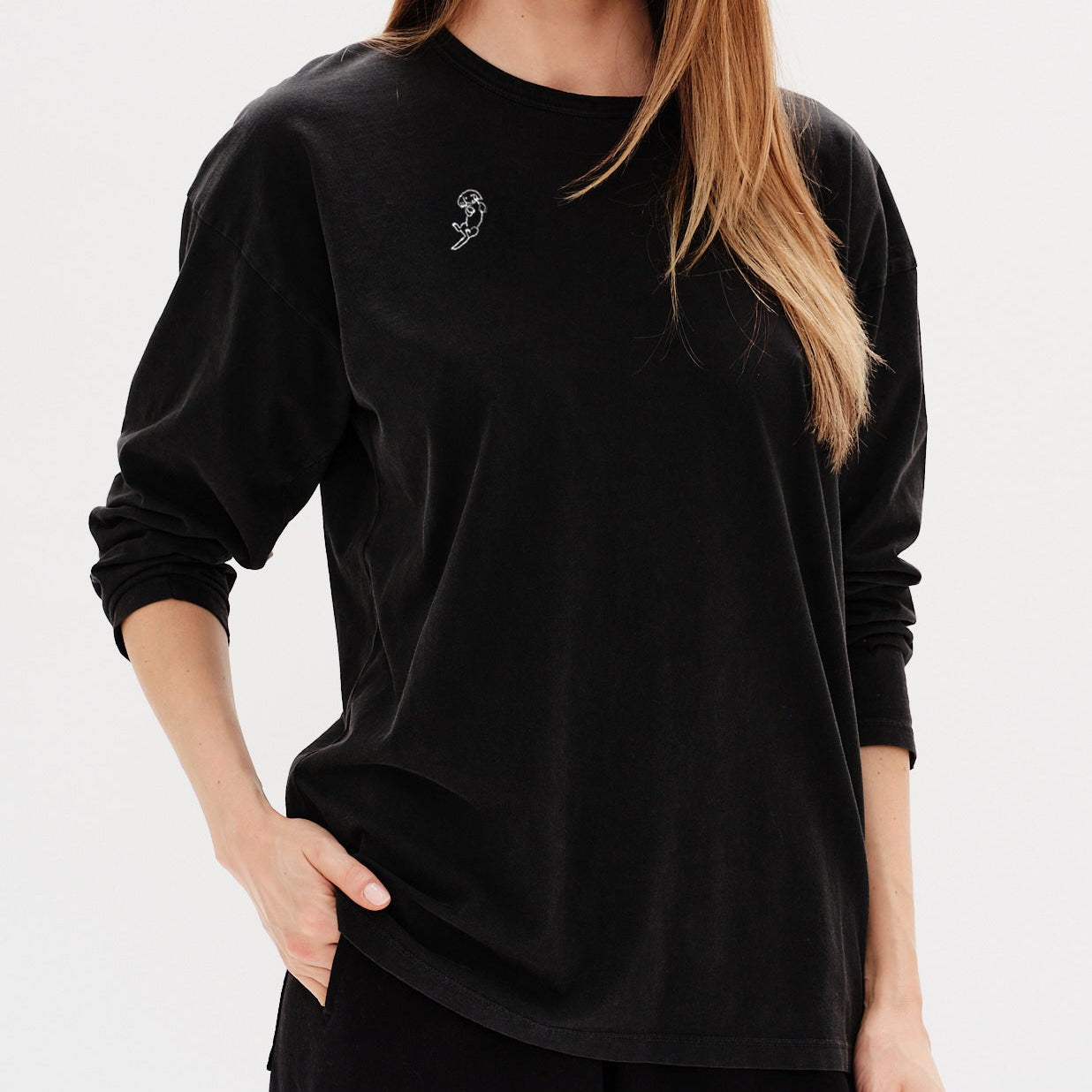 Woman wearing a black long-sleeve t-shirt with a wiener dog long hair embroidery