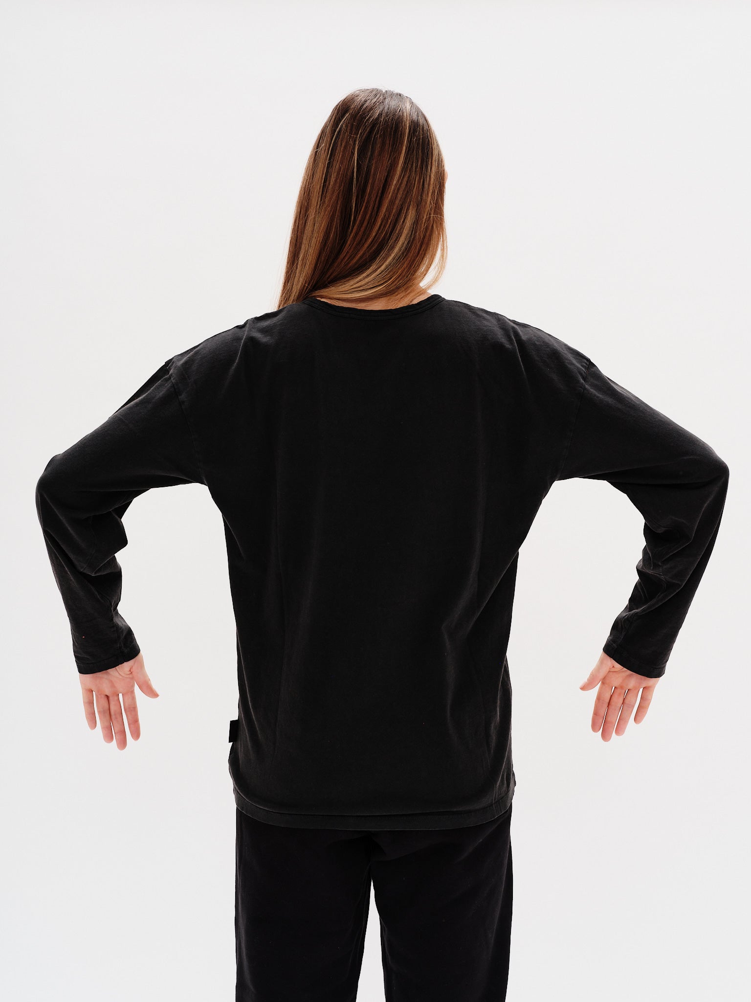 Woman wearing a black long-sleeve t-shirt with a New York embroidery