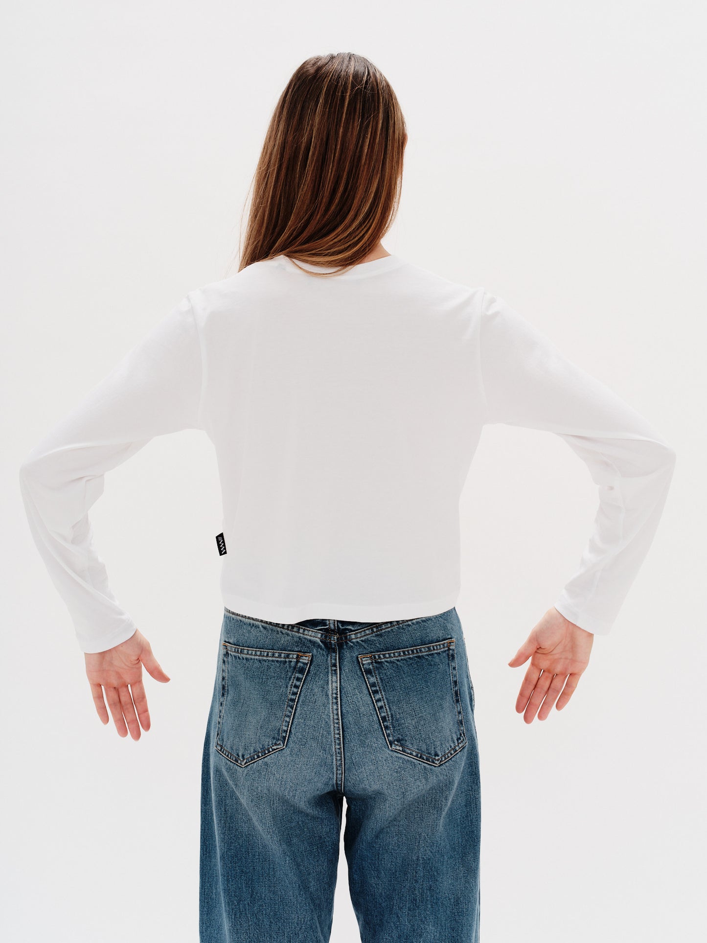 Woman wearing a white long-sleeve t-shirt with a i don´t want to work embroidery