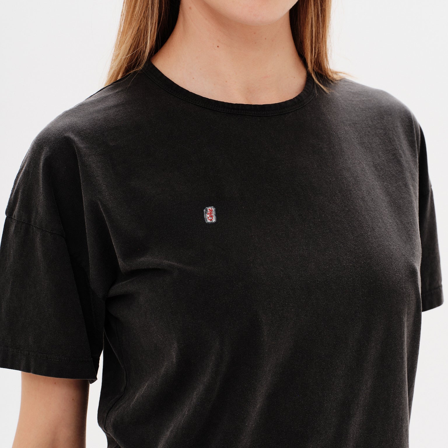 Woman wearing a black t-shirt with a diet coke embroidery