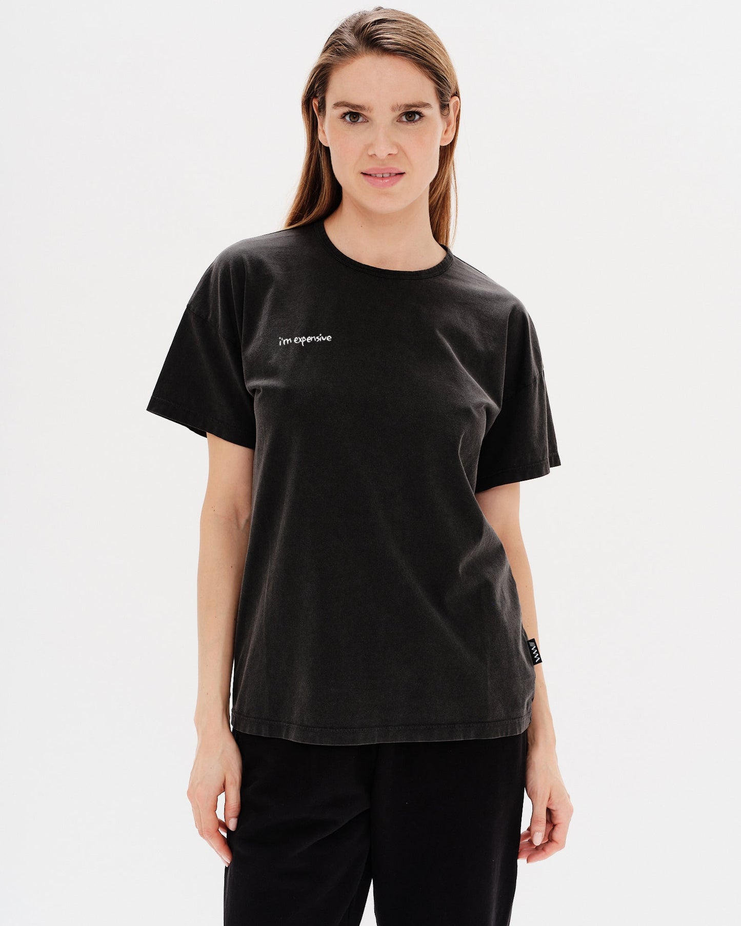 Woman wearing a black t-shirt with a i'm expensive embroidery