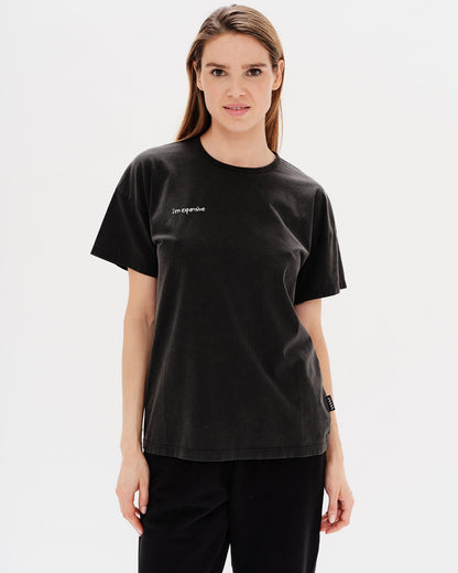Woman wearing a black t-shirt with a i'm expensive embroidery