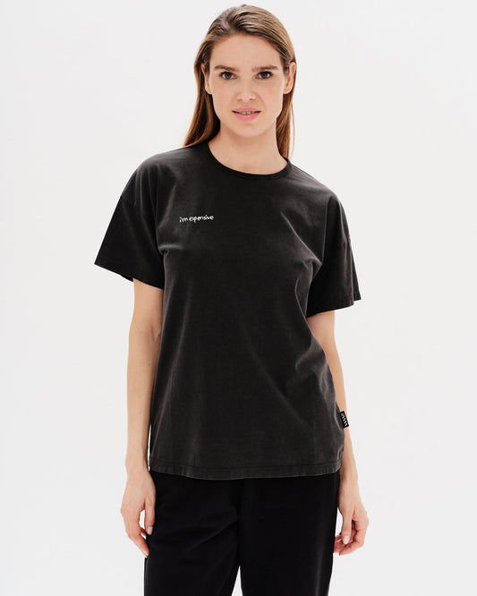 Woman wearing a black t-shirt with a i'm expensive embroidery