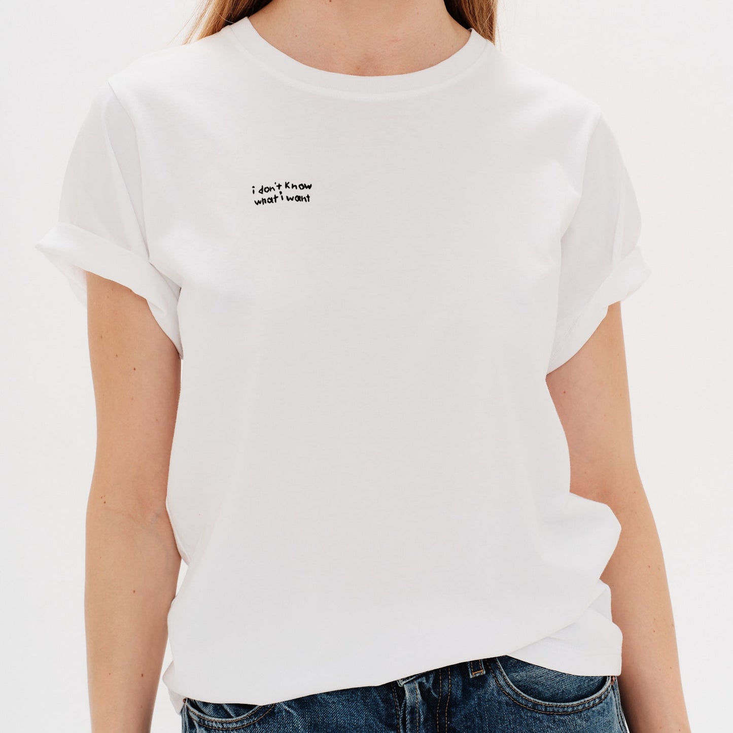 Woman wearing a white t-shirt with a i don't know what i want embroidery