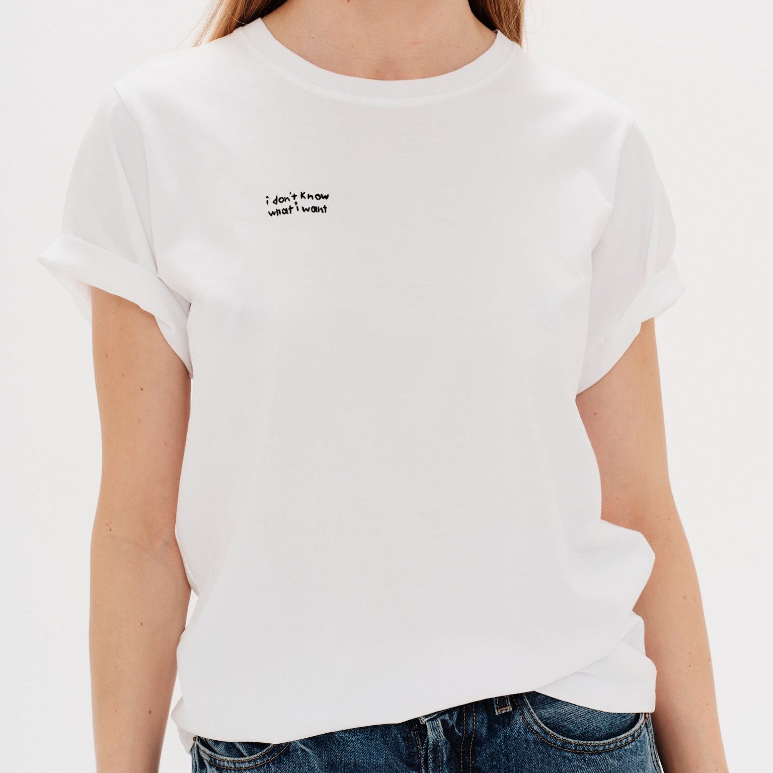 Woman wearing a white t-shirt with a i don't know what i want embroidery