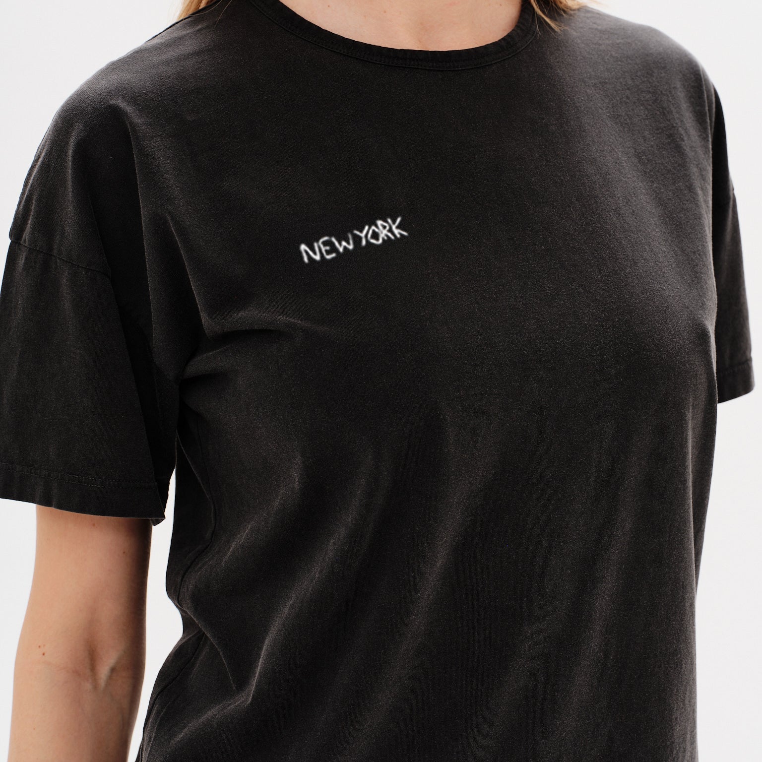 Woman wearing a black t-shirt with New York embroidery