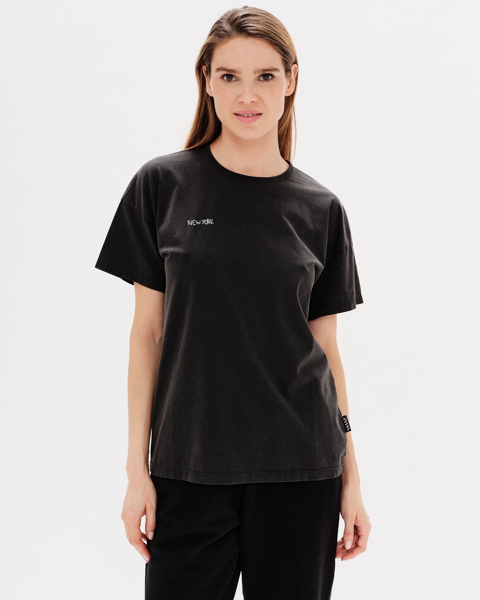Woman wearing a black t-shirt with New York embroidery