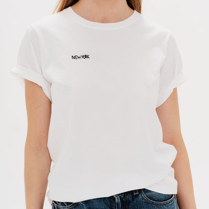 Woman wearing a white t-shirt with New York embroidery