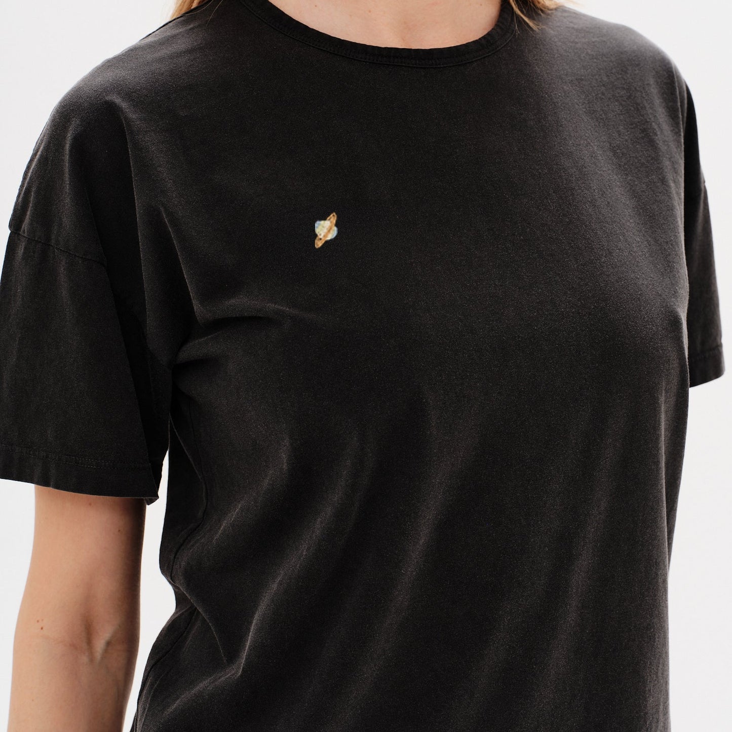 Woman wearing a white t-shirt with planet embroidery