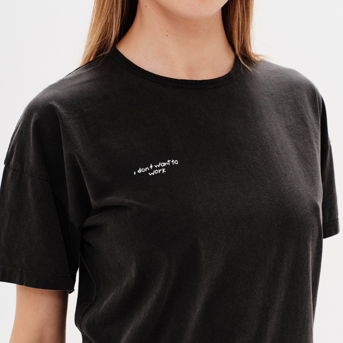 Woman wearing a black t-shirt with a i don't want to work embroidery