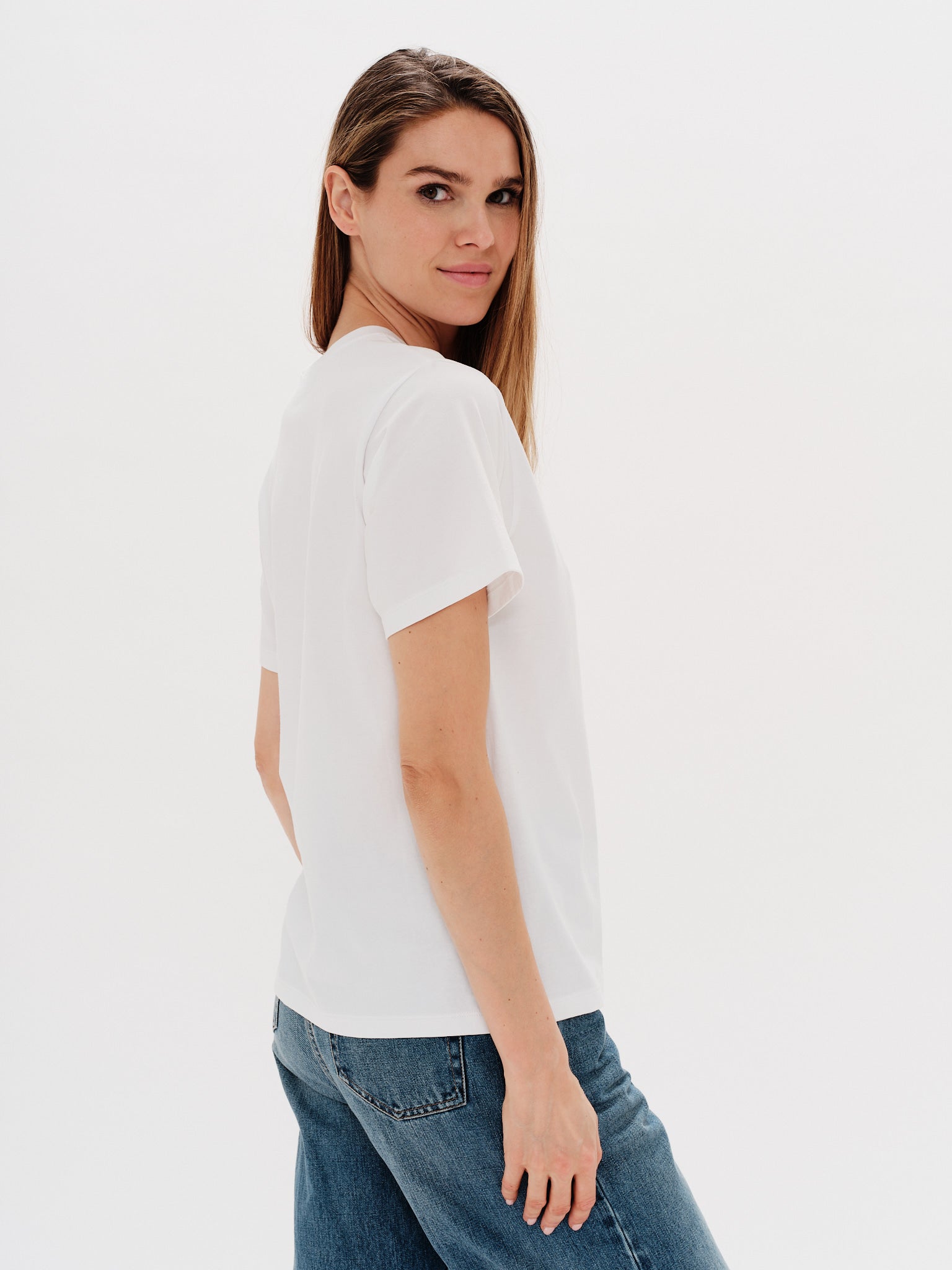Woman wearing a white t-shirt with a i don't want to work embroidery