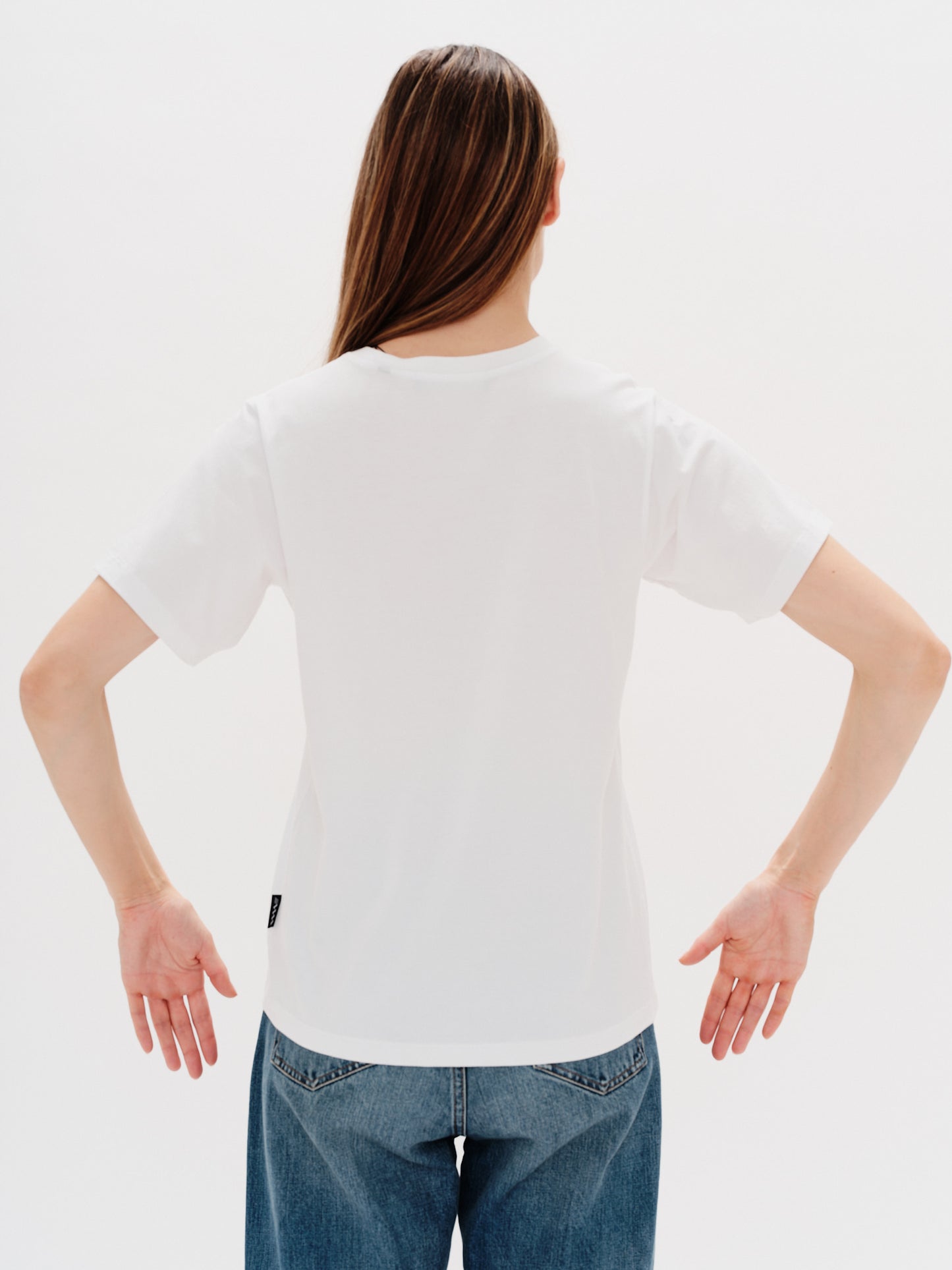 Woman wearing a white t-shirt with a i don't want to work embroidery