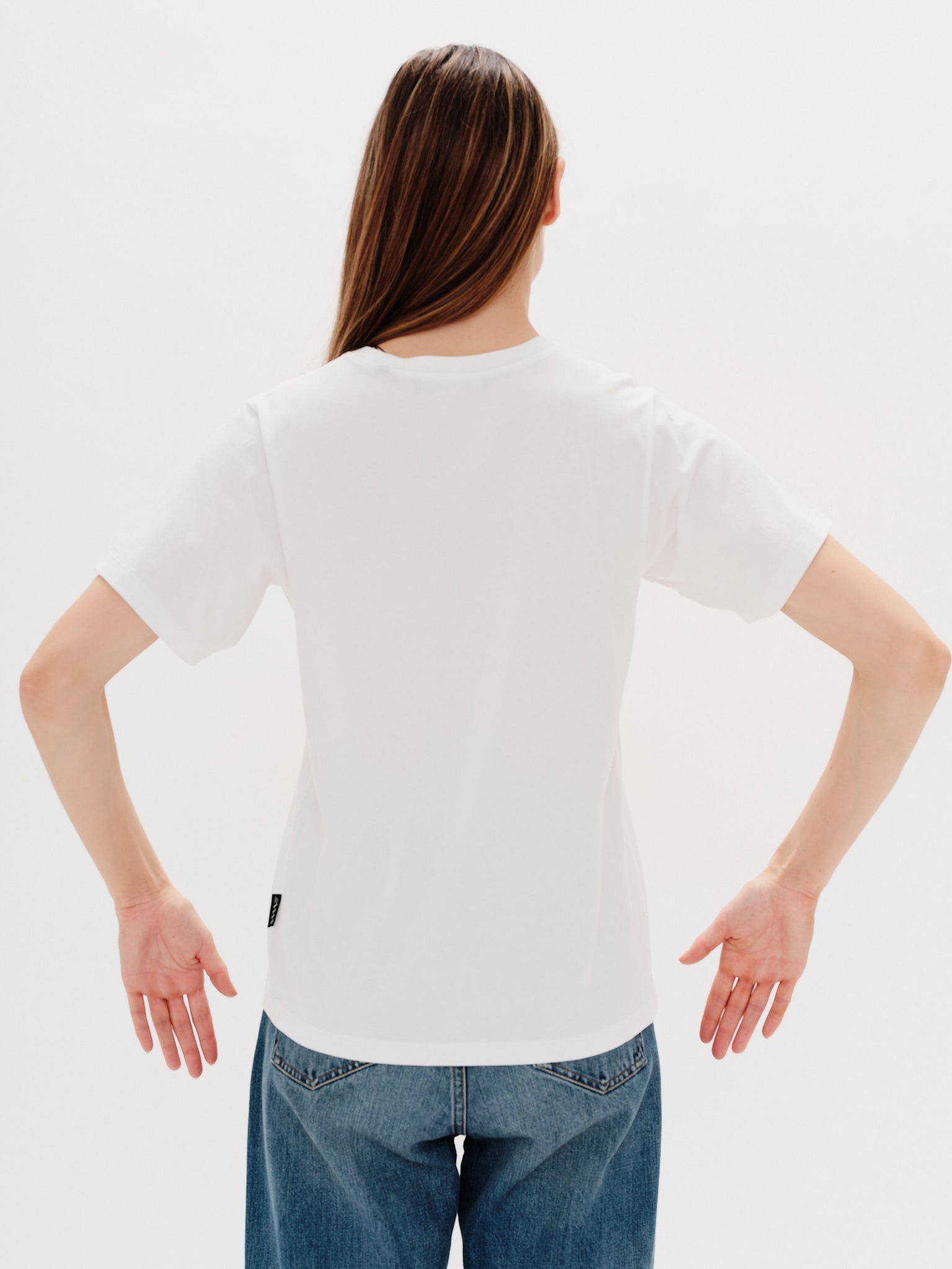 Woman wearing a white t-shirt with a i don't want to work embroidery