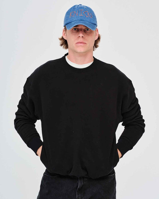 Man wearing a black sweatshirt and blue cap