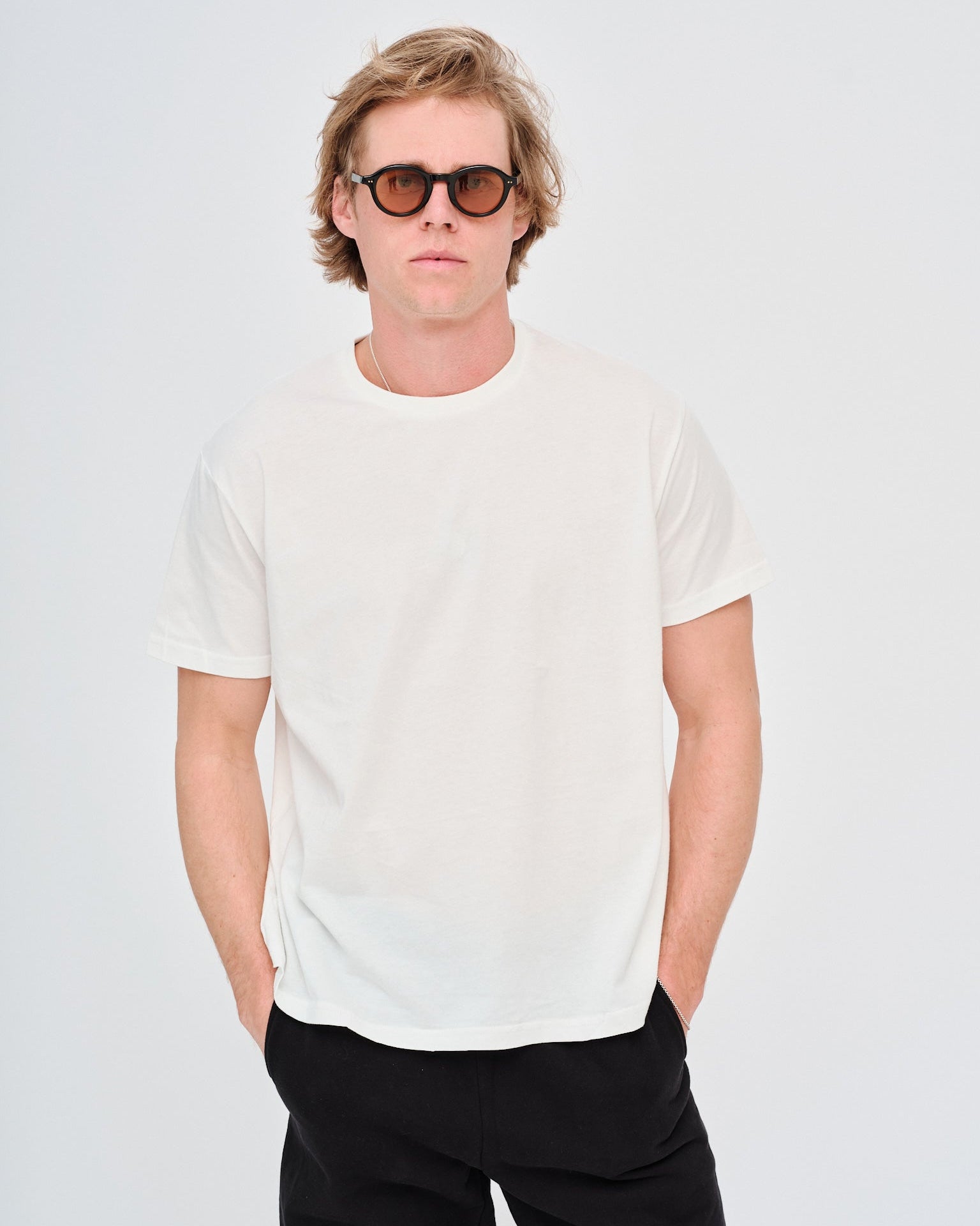 Man wearing a plain white t-shirt and black sunglasses